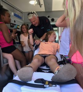 A kid at Tumble Jungle reacts to being put on a cot during an ambulance demonstration in Hot Springs.