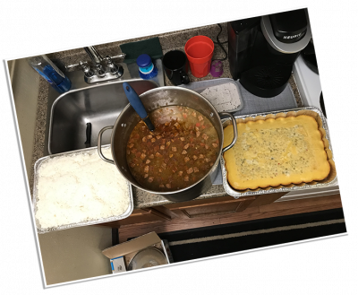 A pot of gumbo with cornbread and rice sitting on the stove in the LifeNet Air hangar. It was cooked by a family as a thank you gift for transporting their son.