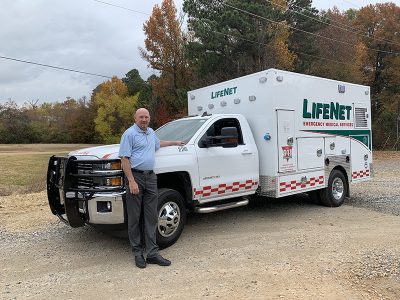 LifeNet General Manager Kelly McCaulley stands in front of a new ambulance.