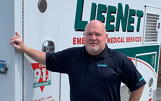 Klay Hall, LifeNet Director of Operations in Hot Springs, Arkansas, stands beside a LifeNet Ambulance.